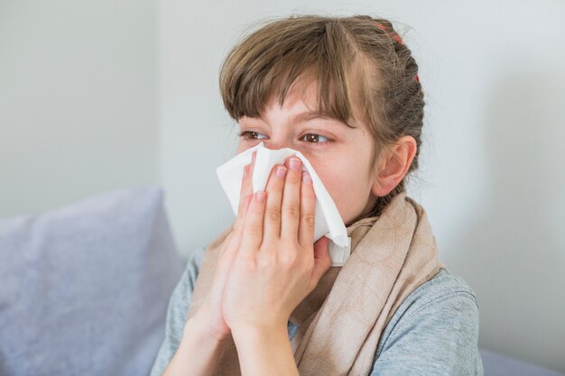 Ragazza malata che soffia il naso