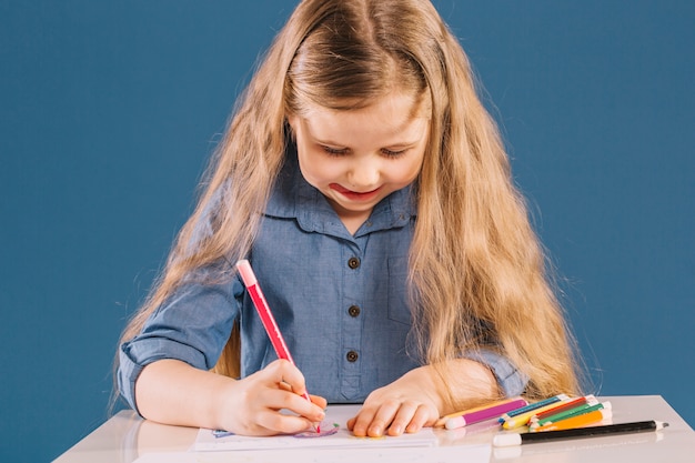 Ragazza messa a fuoco che disegna alla tavola