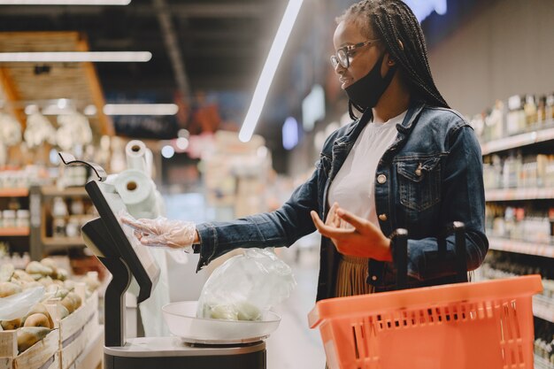 Ragazza nera con una maschera compra un cibo