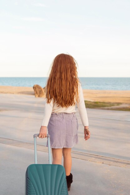 Ragazza piena del colpo che trasporta i bagagli