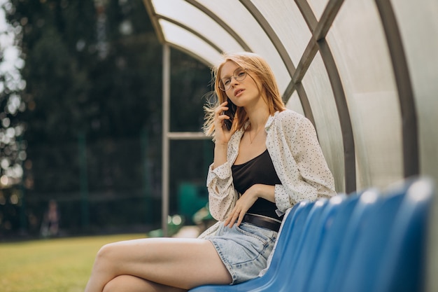 Ragazza pon pon della donna che si siede al campo di calcio