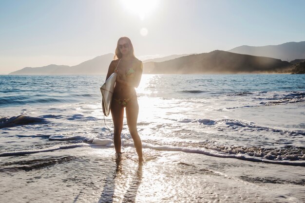 Ragazza posa con la tavola da surf