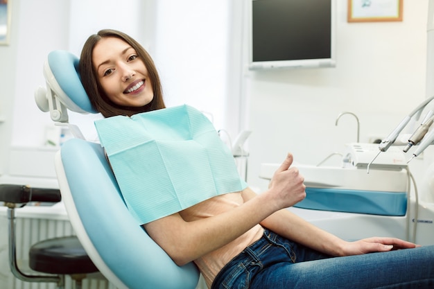 Ragazza positiva sulla sedia del dentista