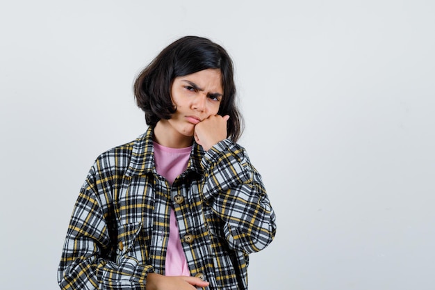 Ragazza preteen che soffre di mal di denti in camicia, vista frontale della giacca.