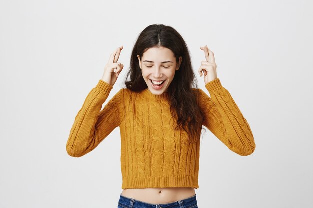 Ragazza promettente incrocia le dita e esprime il desiderio