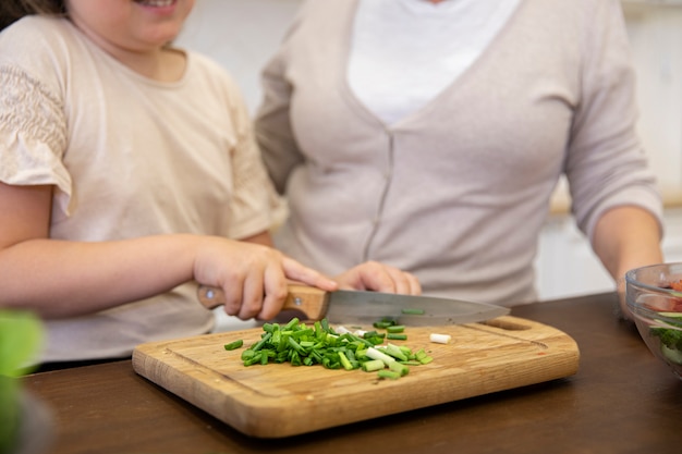 Ragazza ravvicinata che cucina con la nonna