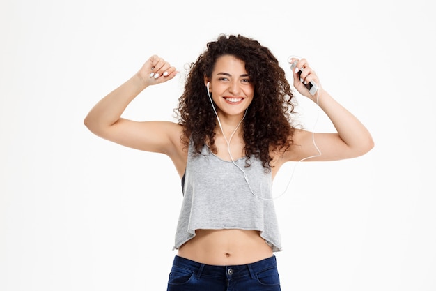 Ragazza riccia di forma fisica che ascolta la musica