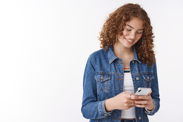 Ragazza ride sorrisi arrossendo compiaciuta leggere commovente messaggio divertente in possesso di smartphone guardare dispositivo display divertito sorridendo felicemente, utilizzare i social media navigare in internet, guardare video interessanti online