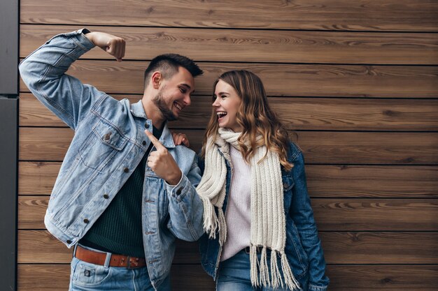 Ragazza romantica in sciarpa lavorata a maglia trascorrere del tempo con il suo fidanzato. Uomo alla moda e donna bionda che si guardano con un sorriso.