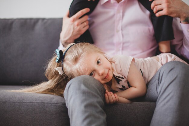 Ragazza sdraiata sulle gambe del padre