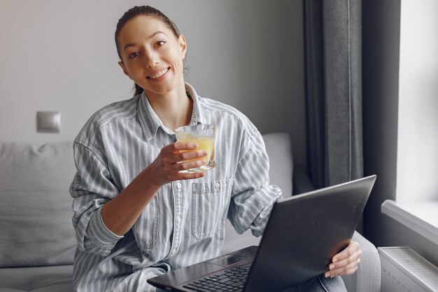 Ragazza seduta a casa e utilizzare il computer portatile