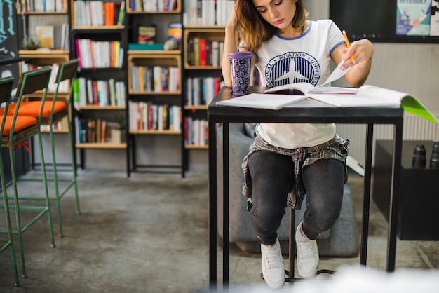 Ragazza seduta a tavola a studiare