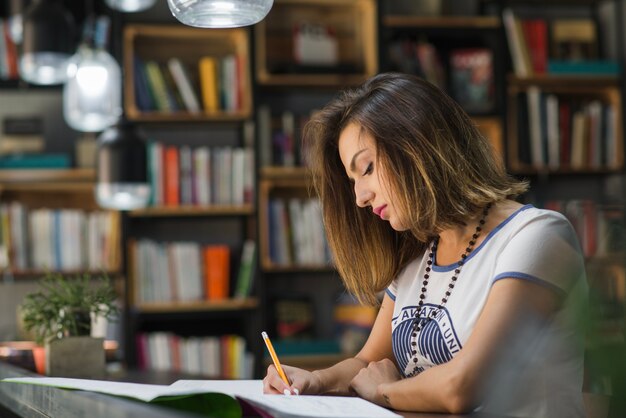 Ragazza seduta a tavola con i quaderni di scrittura