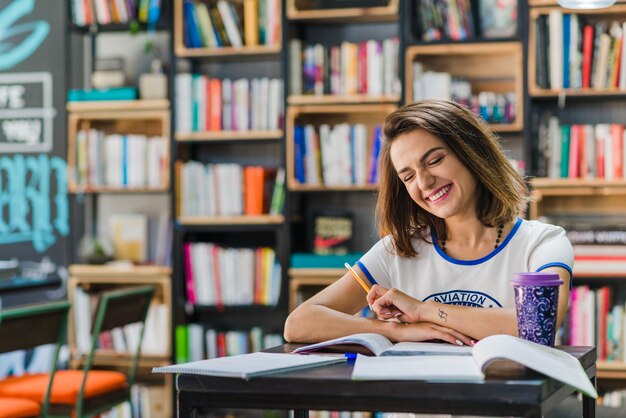 Ragazza seduta a tavola ridendo