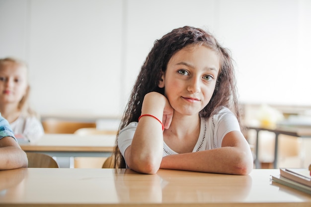 Ragazza seduta alla scrivania di scuola