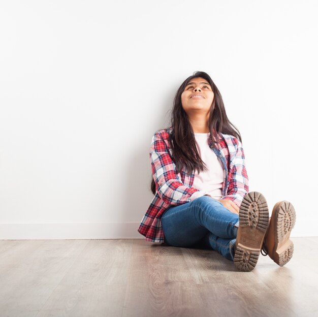 Ragazza seduta sul pavimento guardando il soffitto