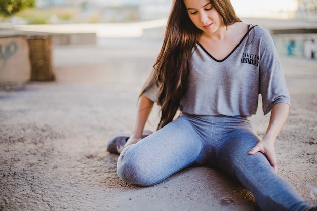 Ragazza seduta sul pavimento in cemento stretching