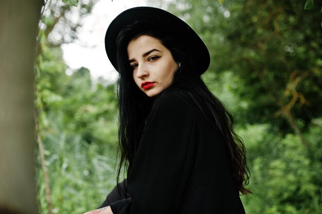Ragazza sensuale tutta in labbra rosse nere e cappello Donna drammatica gotica