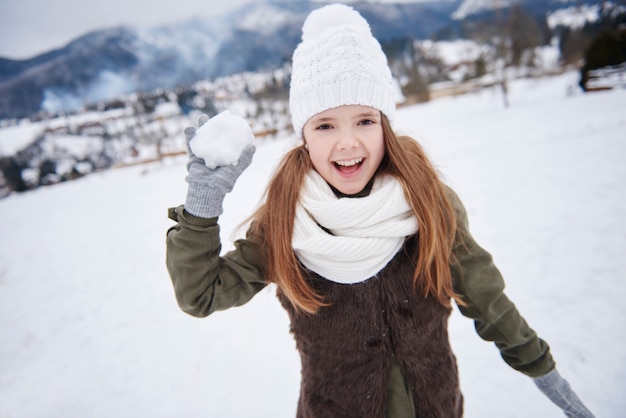 Ragazza sfrenata con palla di neve in mano