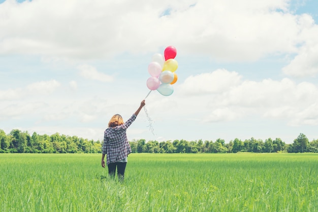 Ragazza sola con palloncini multicolori