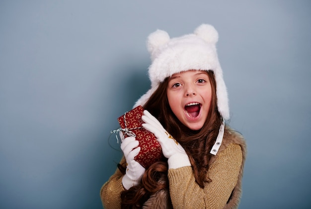 Ragazza sorpresa che gode con il regalo di Natale