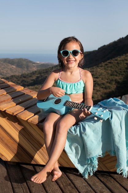 Ragazza sorridente a tutto campo con la chitarra