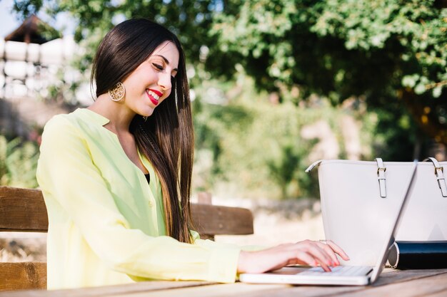 Ragazza sorridente al computer portatile