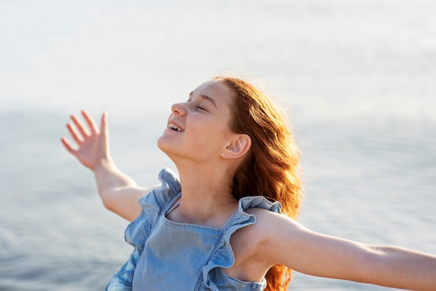 Ragazza sorridente alla vista laterale del mare