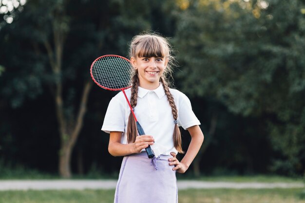 Ragazza sorridente che tiene volano che sta nel parco