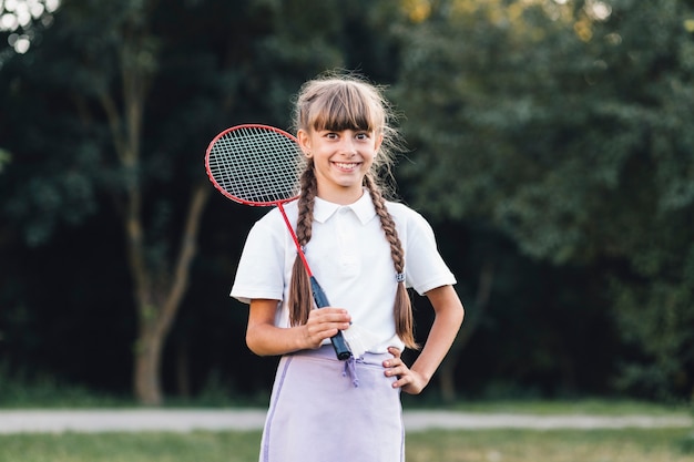 Ragazza sorridente che tiene volano che sta nel parco