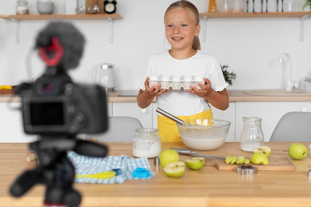 Ragazza sorridente con colpo medio che cucina