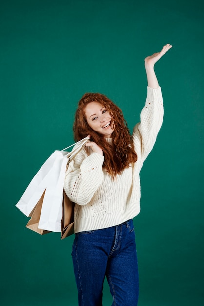 Ragazza sorridente con le borse della spesa in studio di colpo