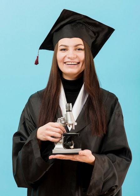 Ragazza sorridente con microscopio