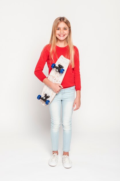 Ragazza sorridente con skateboard