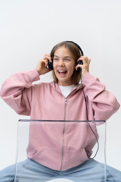 Ragazza sorridente del colpo medio che indossa le cuffie