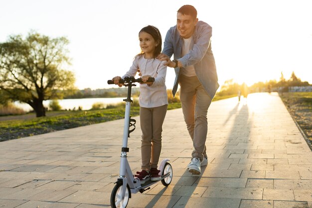 Ragazza sorridente del colpo pieno sullo scooter