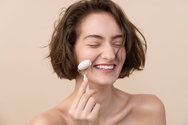 Ragazza sorridente di vista laterale che usa il rullo di giada