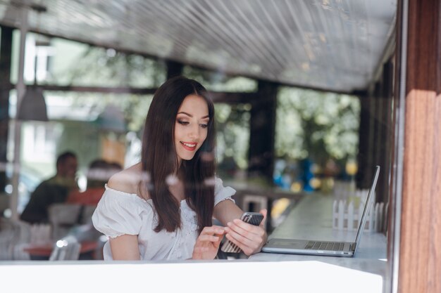 Ragazza sorridente digitando mentre guardando il suo telefono