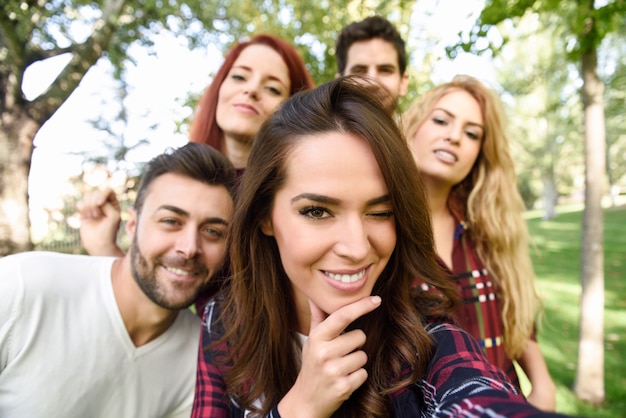 Ragazza sorridente facendo una foto di auto con i suoi amici in giro