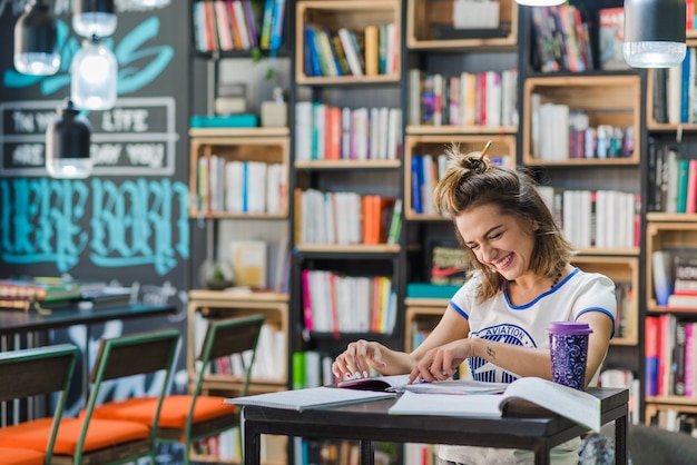 Ragazza sorridente seduta alla lettura del tavolo