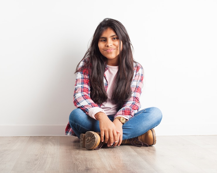 Foto gratuito ragazza sorridente si siede sul pavimento