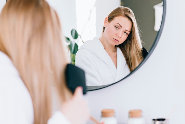 Ragazza spazzolarsi i capelli in bagno