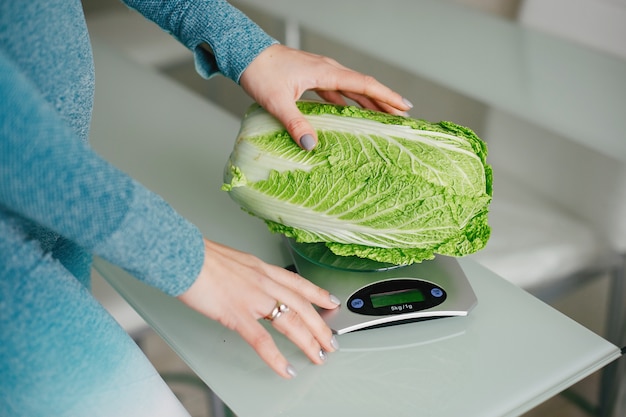 Ragazza sportiva in una cucina con verdure