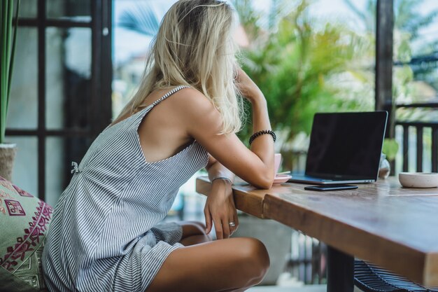 ragazza sta lavorando in un caffè. concetto di freelance, caffè e laptop.