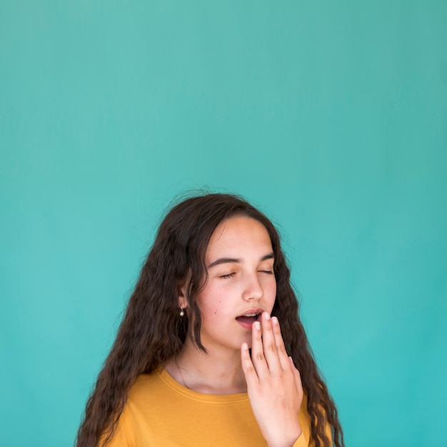 Ragazza stanca che sbadiglia con lo spazio della copia