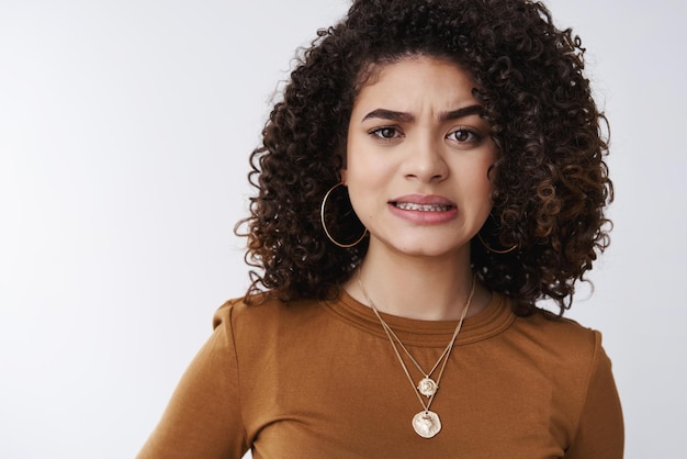 ragazza stringendo i denti stringendo i denti imbarazzante accigliata dispiaciuto provare empatia amico punta urtata dolorosamente in piedi sconvolto nervoso