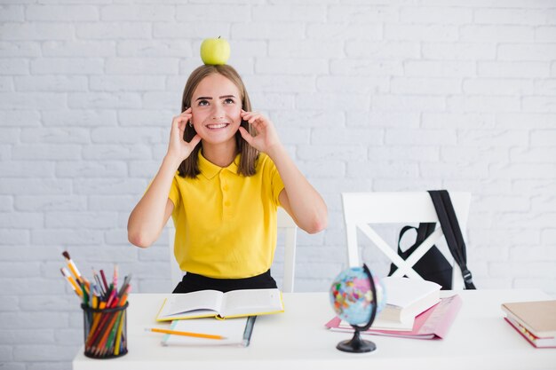 Ragazza studente con la mela sulla testa