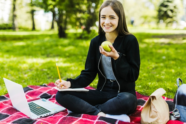 Ragazza studiare e mangiare una mela