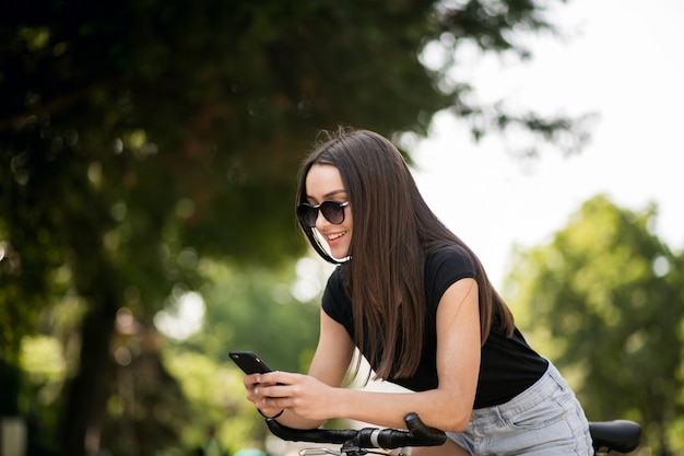 Ragazza su una bicicletta con il telefono