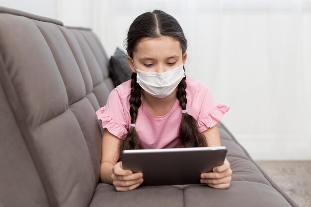 Ragazza sul divano indossando maschera